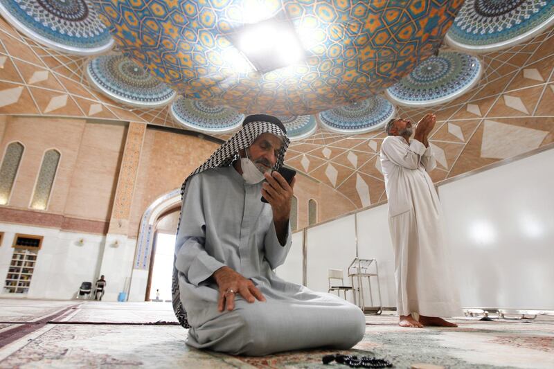 A man using his cellphone prays in a mosque during the holy month of Ramadan in Najaf, Iraq. Reuters