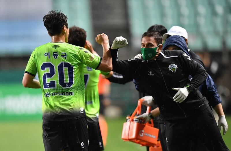 Lee Dong-gook celebrates his goal with his team staff. AFP