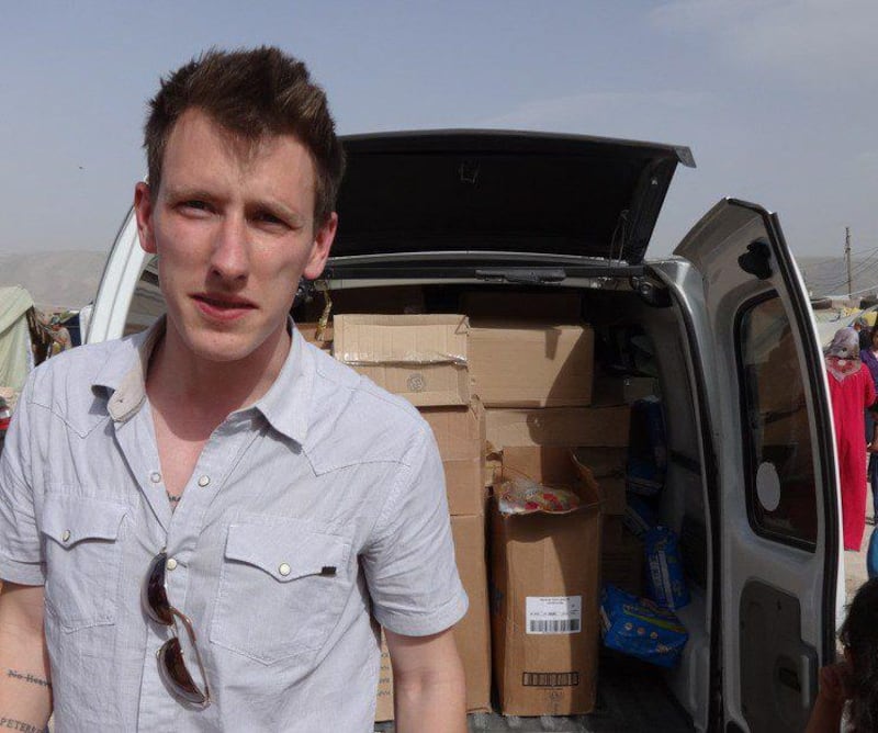 This undated file photo provided by the Kassig Family shows Peter Kassig standing in front of a truck filled with supplies for Syrian refugees. A new video claims the US aid worker was beheaded. Courtesy Kassig Family / AP Photo