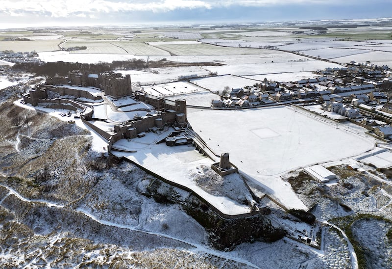 Bamburgh Castle is surrounded by snow in Northumberland. PA