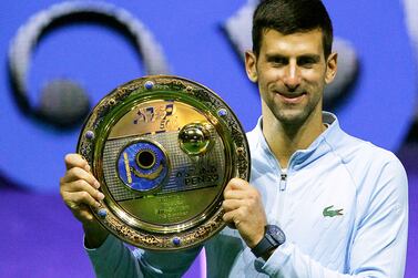 Serbia's Novak Djokovic celebrates with the trophy after defeating Greece's Stefanos Tsitsipas in their men's singles final match at the Astana Open tennis tournament in Astana on October 9, 2022.  (Photo by AFP)