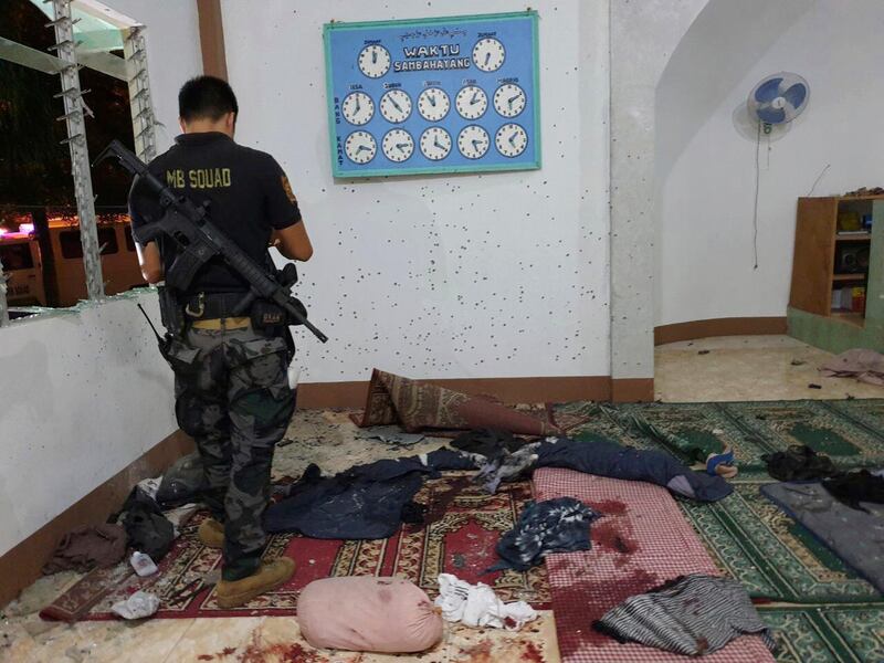 In this photo provided by WESMINCOM Armed Forces of the Philippines, a police investigator examines the scene of a grenade attack of a Muslim mosque in Zamboanga city in southern Philippines early Wednesday, Jan. 30, 2019. The attack came after suspected militants exploded two bombs at a Roman Catholic Cathedral in southern Jolo, Sulu province, during a Sunday Mass. (WESMINCOM Armed Forces of the Philippines via AP)