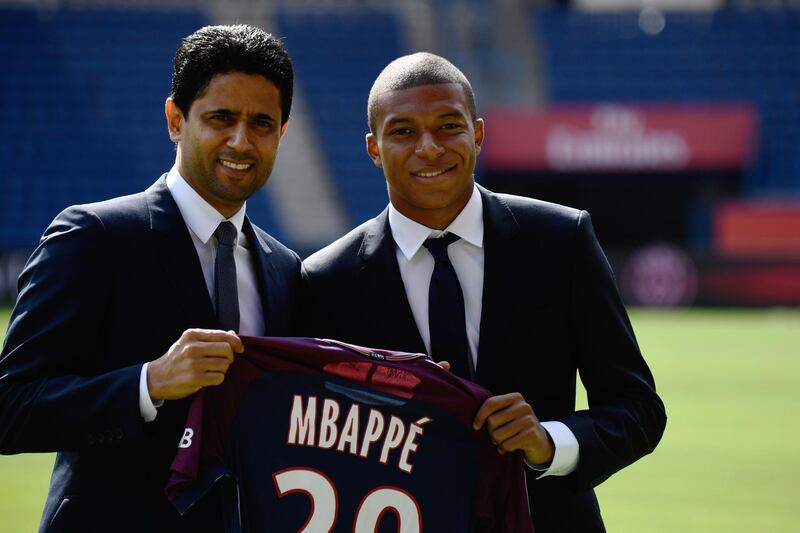Paris Saint-Germain's new forward Kylian Mbappe (R) together with Paris Saint Germain's Qatari president Nasser Al-Khelaifi holds his jersey during his presentation at the Parc des Princes stadium in Paris on September 6, 2017. - The 18-year-old striker moved to PSG in a season-long loan deal with a 180 million euro buy-out clause attached, making him the second most expensive player of all time behind new teammate Neymar. (Photo by CHRISTOPHE SIMON / AFP)