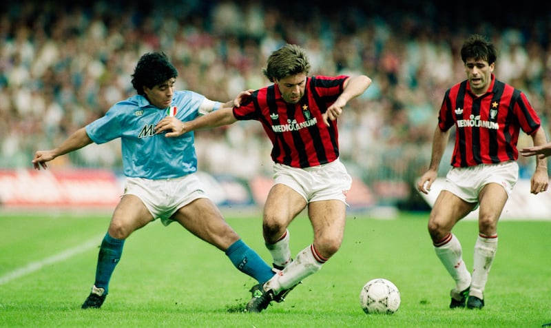 Future AC Milan manager Carlo Ancelotti holds off Napoli's Diego Maradona during a match in 1990