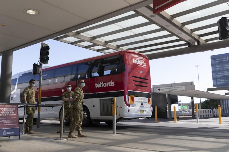 Army personnel watch as a charter bus that unloaded crew from the Ruby Princess Cruise ship departs Sydney Airport in Sydney, Australia. Getty