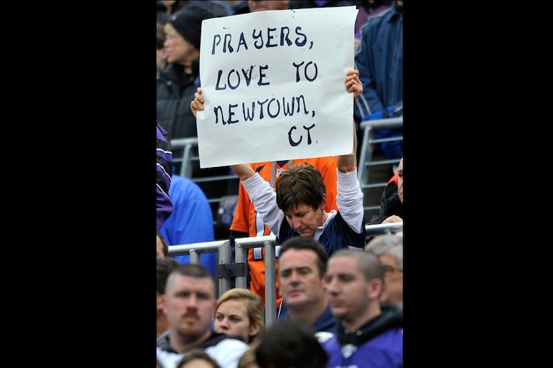 Baltimore Ravens fans pause during a moment of silence to honor those killed during the shooting rampage at Sandy Hook Elementary School in Newtown, Conn. before the first half of an NFL football game against the Denver Broncos. Gail Burton / AP Photo