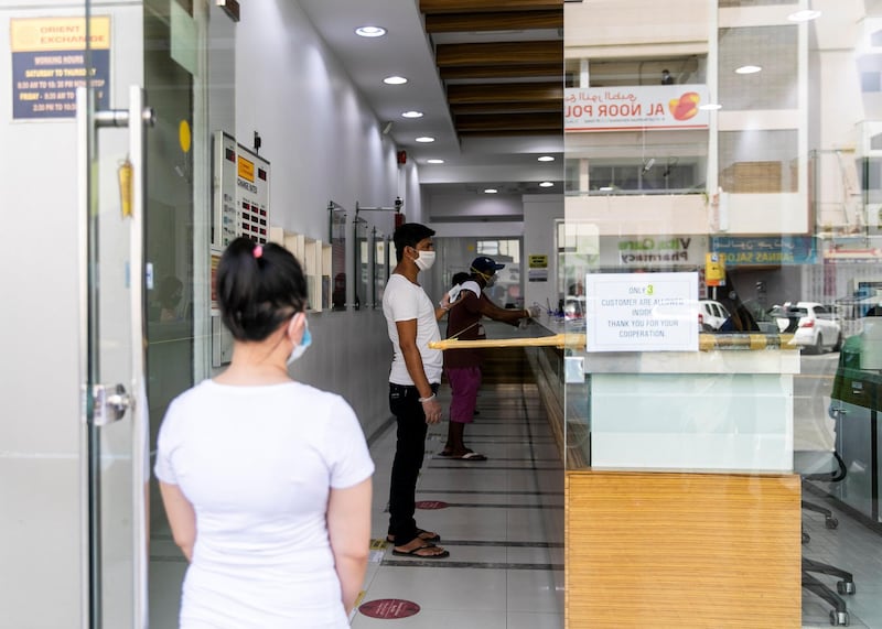 DUBAI, UNITED ARAB EMIRATES. 4 APRIL 2020. 
People line up at the money exchange outside Satwa. 
Usually a vibrant area, Satwa’s shops have closed temporarily to help UAE’s plan to prevent the spread of the coronavirus.

(Photo: Reem Mohammed/The National)

Reporter:
Section: