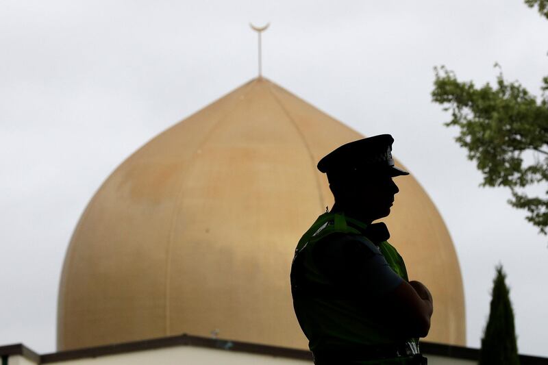 A police officer stands in a park near the Al Noor mosque in Christchurch, New Zealand, Sunday, March 15, 2020. A national memorial in New Zealand to commemorate the 51 people who were killed when a gunman attacked two mosques one year ago has been canceled due to fears over the new coronavirus. (AP Photo/Mark Baker)