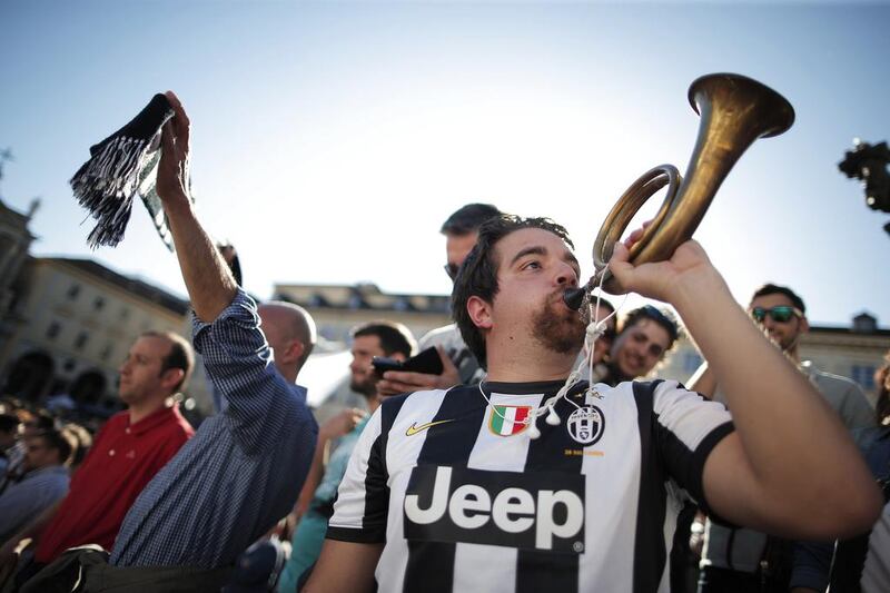 A Juventus supporter blows a horn as he celebrates the club's Serie A championship. Marco Bertorello / AFP / May 4, 2014
