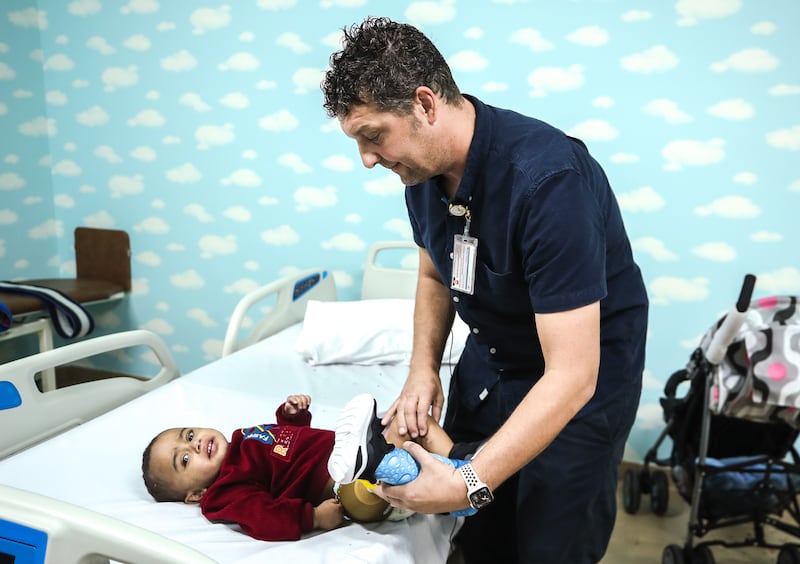 Technician Martin Fischbach checks on one-year-old Gaza resident Rakan Saif