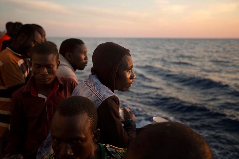 FILE - In this June 17, 2017 file photo, sub-Saharan migrants stand on the deck of the Golfo Azzurro rescue vessel. after being rescued by members of Proactive Open Arms, as they arrive at the port of Pozzallo, south of Sicily, Italy. Under a deal backed by Italy, Libya��������s struggling government in Tripoli has paid militias that were once involved in smuggling migrants to now prevent migrants from crossing the Mediterranean to Europe, one reason for a dramatic drop in the traffic, according to militia and security officials. (AP Photo/Emilio Morenatti, File)