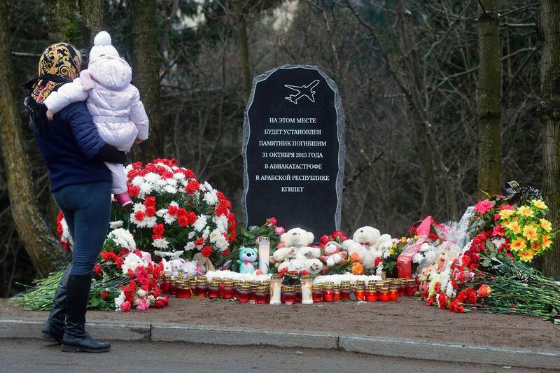 In the town of Vsevolozhsk outside Saint Petersburg on October 31, 2016, a woman with a baby is mourning in front of the foundation stone for a Garden of Memory commemorating the 224 people killed in the bombing of a Russian airliner over Egypt one year ago. Olga Maltseva/AFP