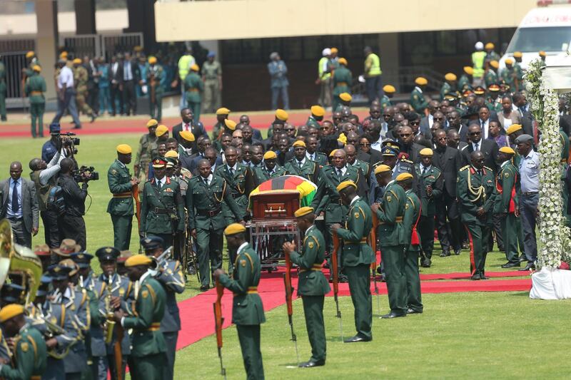 The casket of former president Robert Mugabe, covered by the national flag and followed by family and dignitaries, arrives for a state funeral at the National Sports Stadium in the capital Harare, Zimbabwe. African heads of state and envoys are gathering to attend a state funeral for Mugabe, whose burial has been delayed for at least a month until a special mausoleum can be built for his remains. AP Photo