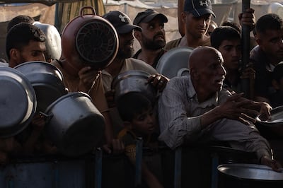 Displaced Palestinians wait to collect food donations in Khan Younis.  EPA