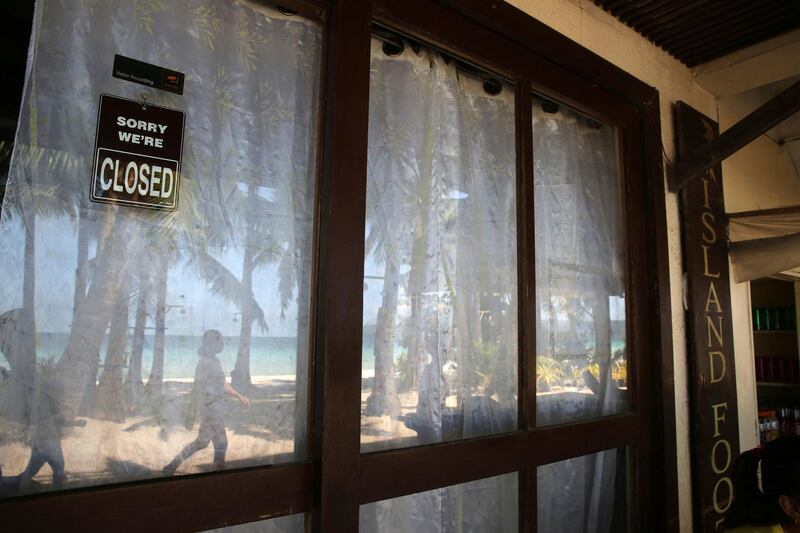 A closed sign hangs on the window of a beachfront shop as the government implements the temporary closure of the country's most famous beach resort island of Boracay. Aaron Favila / AP Photo