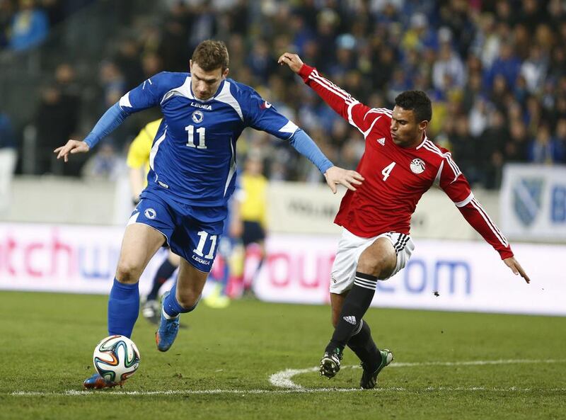 Bosnia-Herzegovina's Edin Dzeko, left, fights for the ball with Egypt's Ahmed Said Oka during their international friendly in Innsbruck, Austria, on March 5, 2014.  Pierre Teyssot / AFP

