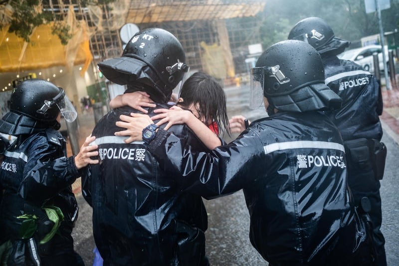 Police officers carry a girl out of a collapsed school in Hong Kong. Getty Images