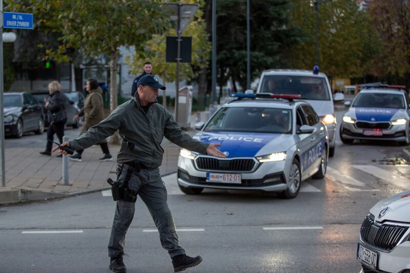 A Kosovo police officer directs the traffic around the stadium. AP