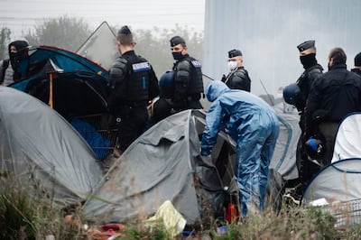French police open tents as migrants are evacuated from a camp near Dunkirk, in northern France. AP Photo