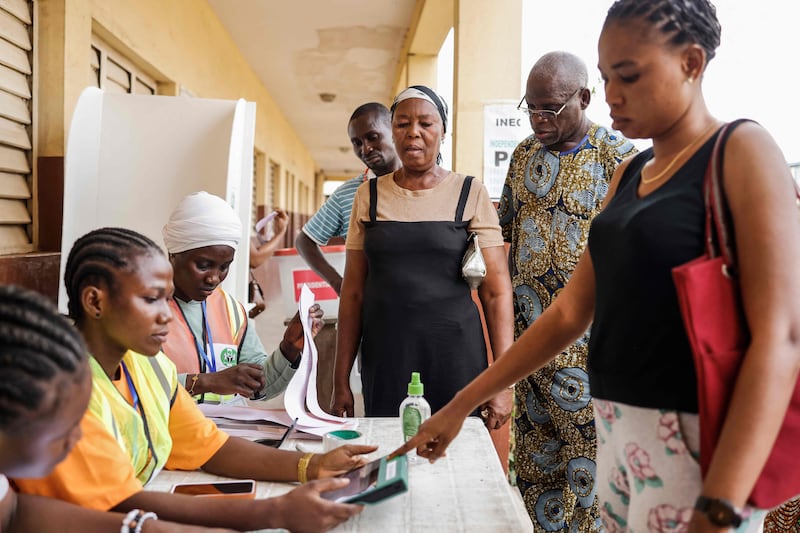 A voter gets her information checked by an Independent National Electoral Commission official at a polling station in Agege, Lagos. AFP
