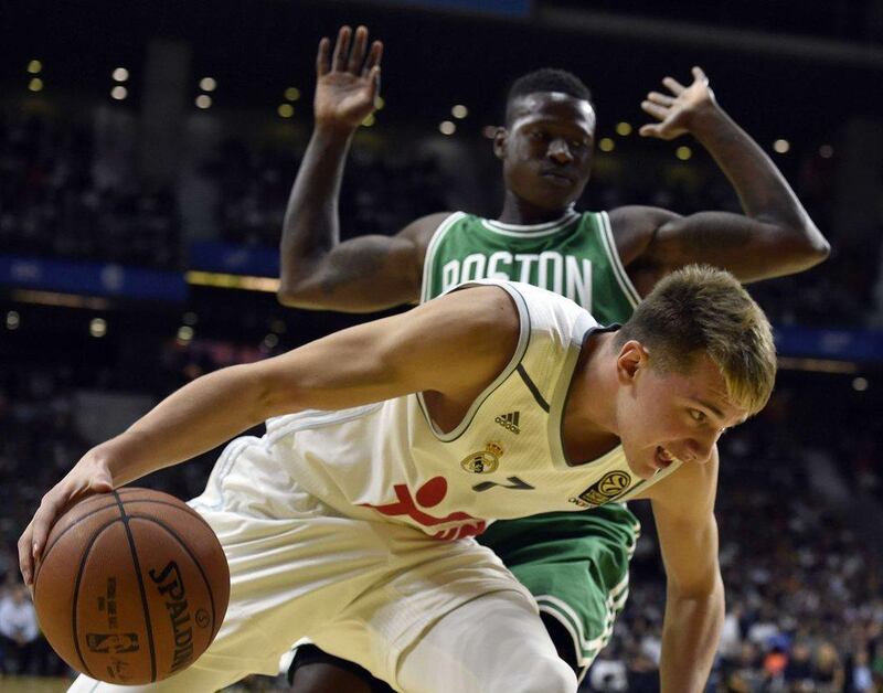 Real Madrid’s Luca Doncic dribbles by Terry Rozier of the Boston Celtics during their pre-season game on Thursday night in Madrid. Gerard Julien / AFP