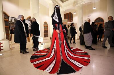 A model displays a dress by Kuwaiti designer Abdullah Al-Saleh named 'Althafra' inspired by Sadu (traditional Kuwaiti weaving) at a gallery in Kuwait City on January 15, 2019. 'Althafra' was a term used to describe the most skillful Bedouin female weaver. 
The piece was created using parts of pillows, constructed, designed and woven from camel hair in Algeria, and threaded with red and black wool, representing the traditional Kuwaiti Sadu.   / AFP / Yasser Al-Zayyat
