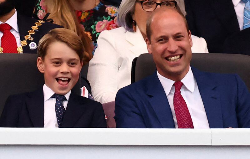 Britain's Prince George of Cambridge (L) and Britain's Prince William, Duke of Cambridge react during the Platinum Party at Buckingham Palace. AFP