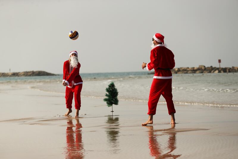 People dressed in Santa Claus costumes play a game of beach volleyball in an event organised by Tel Aviv Municipality ahead of Christmas, in Tel Aviv, Israel.  Reuters
