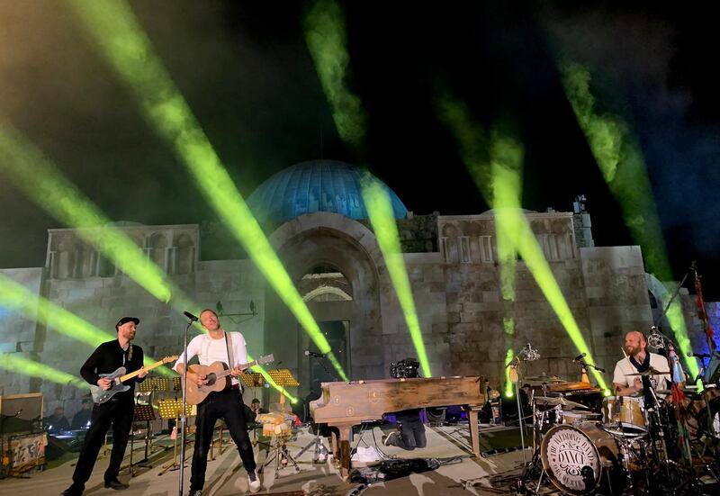Martin, drummer Will Champion, right, and Buckland perform during a concert at the Citadel.