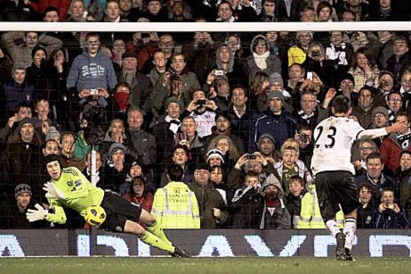 Petr Cech of Chelsea saves a penalty from Clint Dempsey at Craven Cottage.