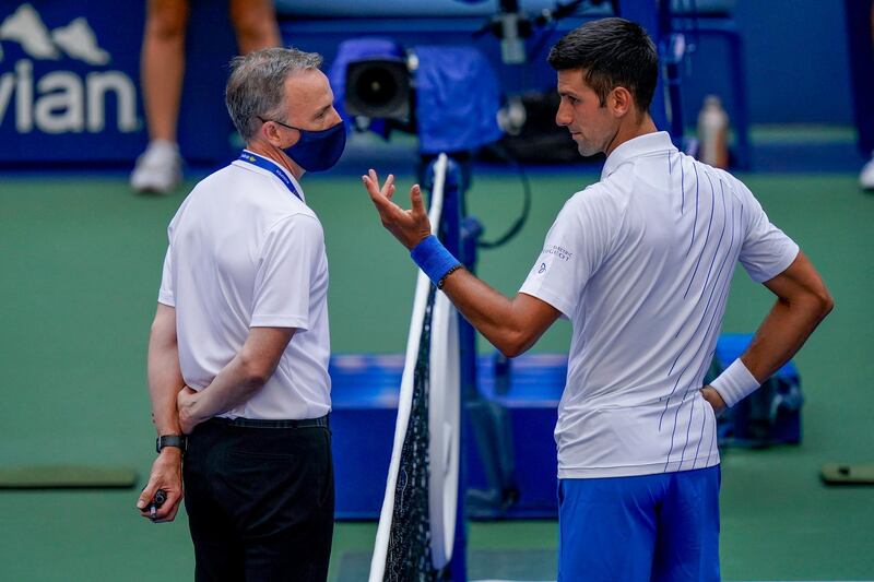 Novak Djokovic talks with the match umpire. PA