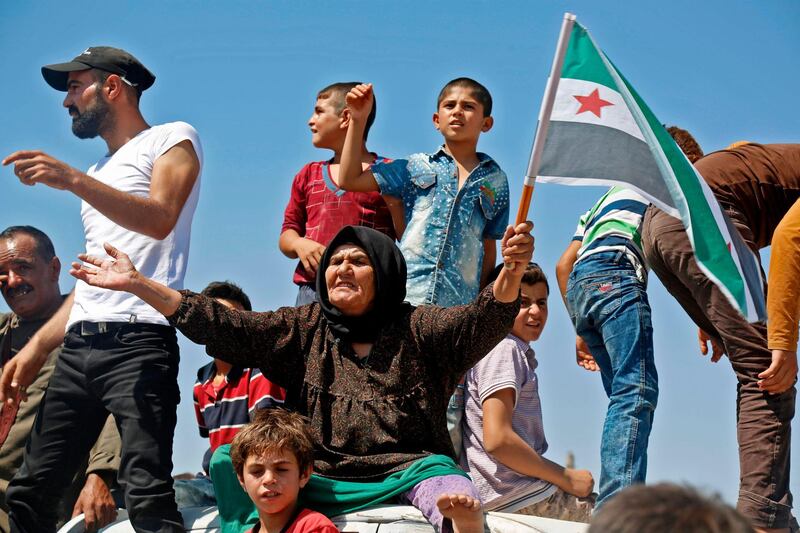 A Syrian protester chants slogans as she waves a flag of the opposition as he protest against the regime and its ally Russia, in the rebel-held town of Maaret al-Numan in the north of Idlib province on August 31, 2018. - Its hospitals are battered, residents heavily dependent on aid and escape routes to neighbouring Turkey sealed. If attacked by government forces, Syria's rebel-held Idlib is poised for a humanitarian calamity. (Photo by Zein Al RIFAI / AFP)