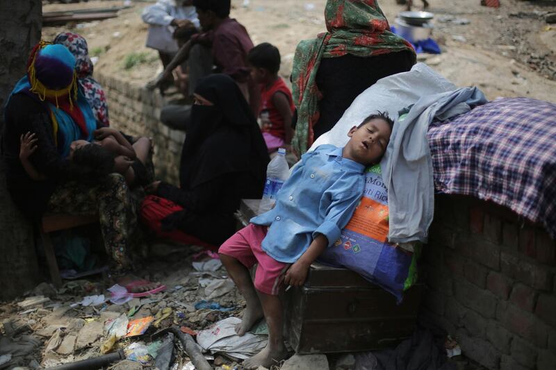 A Rohingya boy takes a nap under the shade of a tree after a fire razed down a Rohingya camp in the Kalindi Kunj area of New Delhi, India. Oinam Anand / AP Photo