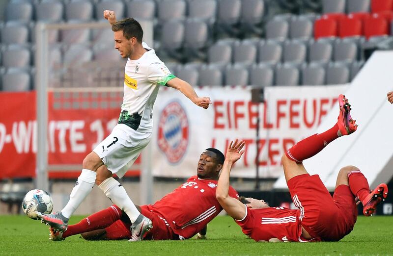 Bayern's David Alaba, centre, and Monchengladbach's Patrick Herrmann, left, challenge for the ball. AP