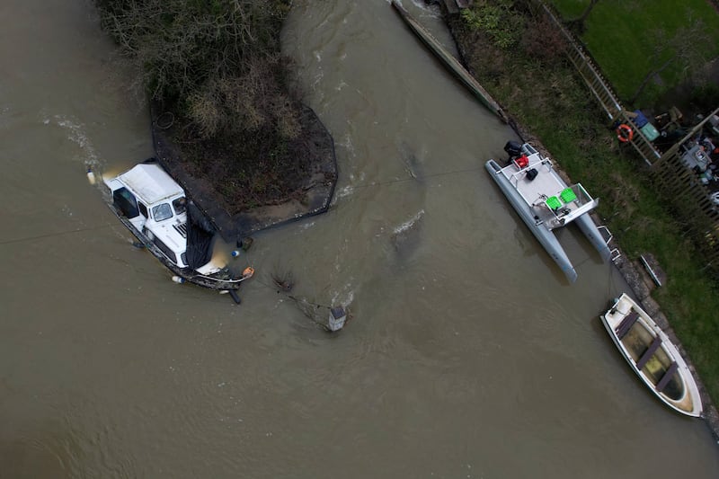 A boat is half-submerged in the flooded Thames in Oxford. AP
