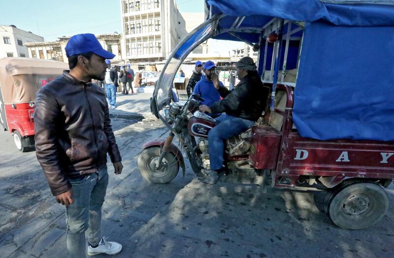 Supporterse of Iraqi's firebrand cleric Moqtada Sadr, recognisable by their signature blue caps, man a makeshift checkpoint in Baghdad's Tahrir square to search vehicles on February 4, 2020. Anti-government demonstrators faced off against followers of the influential cleric Moqtada Sadr in protest squares across Iraq on February 4, a day after one demonstrator was killed in a clash between the two sides. Sadr, a 45-year-old enigmatic militiaman-turned-politician, backed the anti-government rallies when they erupted in October but has split with other demonstrators over the nomination of Mohammad Allawi as prime minister. The cleric endorsed Allawi while other protesters rejected him, saying he was too close to the ruling elite they had been demonstrating against for four months.
 / AFP / -
