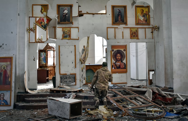 A Ukrainian serviceman prays in a church damaged by a Russian air raid in Orikhiv, Zaporizhzhia region, Ukraine. AP