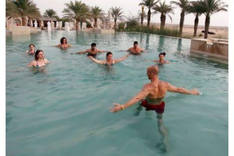 Tom Woolf, the founder of the PTX, leads a "pool recovery session" during an Ultimate Wellness Retreat at the Jumeirah Bab Al Shams Desert Resort & Spa near Dubai. Randi Sokoloff for The National