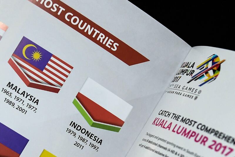 This photo illustration taken on August 20, 2017 shows the Indonesian flag printed upside-down in a copy of the souvenir magazine for the 29th Southeast Asian Games (SEA Games) in Kuala Lumpur. 
Malaysia's Southeast Asian Games organisers have apologised to Indonesia after its flag was printed upside-down in a souvenir magazine, prompting a scathing response from the team and anger on social media. / AFP PHOTO / Mohd RASFAN