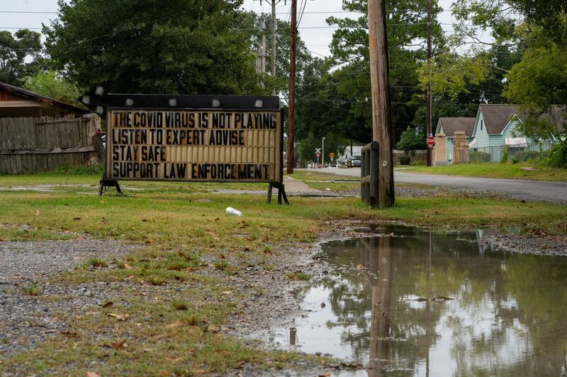 A sign advising on Covid-19 and law enforcement is seen as Hurricane Laura approaches Abbeville, Louisiana, US. Reuters