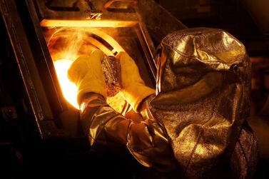 A refinery technician puts a gold 'button' into a furnace at Newmont Mining's Carlin gold mine operation in the US. The precious metal is often considered a safe haven by investors in troubled financial times. Photo: Reuters