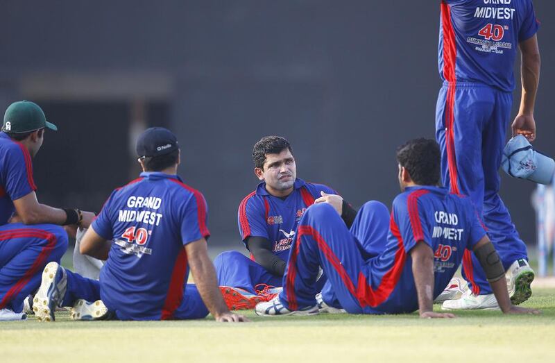 Kamran Akmal is seen with teammates during a break in the semi-finals on Thursday in the Bukhatir Cricket League in Sharjah. Jeffrey E Biteng / The National / June 26, 2014