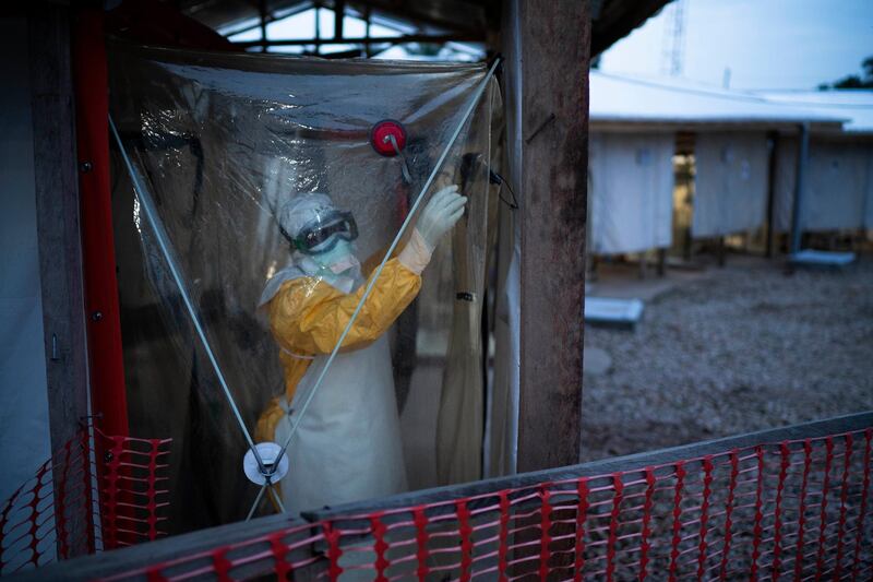 A health worker wearing a protective suit enters an isolation pod to treat a patient at a treatment center in Beni, Congo. AP