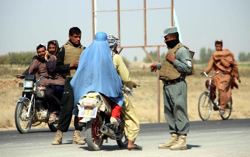 epa08743208 Afghan security officials stand guard on a checkpoint on Helmand-Kandahar highway after Taliban launched first large-scale attack on the capital of southwestern Helmand province in Afghanistan since the signing of a peace deal with the United States in late February, in Lashkargah, Helmand, Afghanistan, 14 October 2020. The fighting began on Sunday on the outskirts of Lashkargah and its surrounding districts and continues.  EPA/WATAN YAR