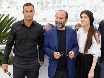 'A Hero' director Asghar Farhadi, centre, with castmates Amir Jadidi and Sarina Farhadi at the 74th Cannes Film Festival on Wednesday, July 14, 2021. Reuters