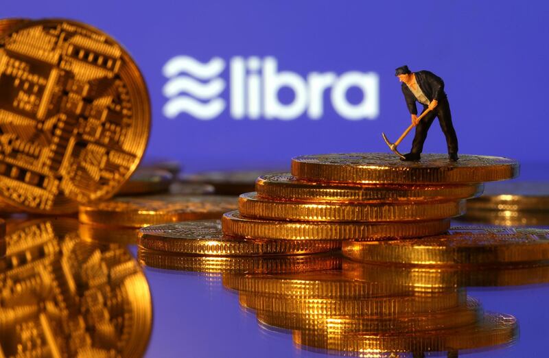 FILE PHOTO: A small toy figure stands on representations of virtual currency in front of the Libra logo in this illustration picture, June 21, 2019. REUTERS/Dado Ruvic/Illustration/File Photo