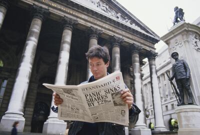 A young man reads a copy of the Evening Standard outside the Royal Exchange in London, with a headline referring to that day's stock market crash, known as Black Monday, 19th October 1987. Getty Images