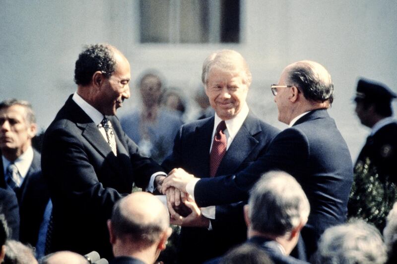 US President Jimmy Carter (C) congratulates Egyptian President Anwar al-Sadat (L) and Israeli Premier Menachem Begin (R) in three-way handshake on March 26, 1979 on the north lawn of the White House, Washington DC,  after signing the historic US-sponsored peace treaty between Israel and Egypt. In 1978, Israel and Egypt sealed a historic agreement promising peace and security to people in the Middle East, the Camp David Accords. (Photo by - / CONSOLIDATED NEWS PICTURES / AFP)