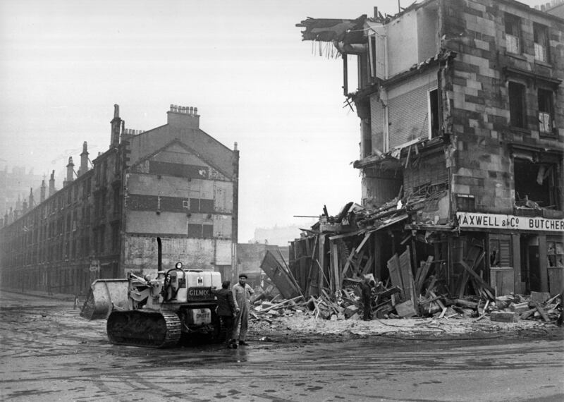 Workmen and a bulldozer beside a tenement being demolished in the Gorbals area of Glasgow in the 1960s. The tenements that had previously occupied the site were among the worst slums in Britain. Getty Images
