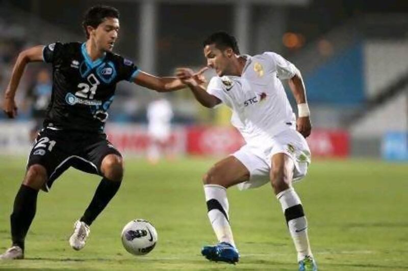 ABU DHABI, UNITED ARAB EMIRATES - April 17, 2012 - Baniyas' Mohamed Jabeer races against Al Ittihad's Naif Hazazi for control of the ball during game action between Baniyas and Al Ittihad on Tuesday, April 17, 2012. ( DELORES JOHNSON / The National )